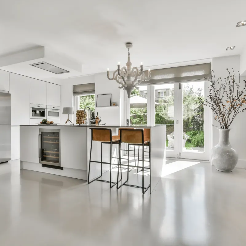 A bright white living room with timber floors and a soft grey sofa